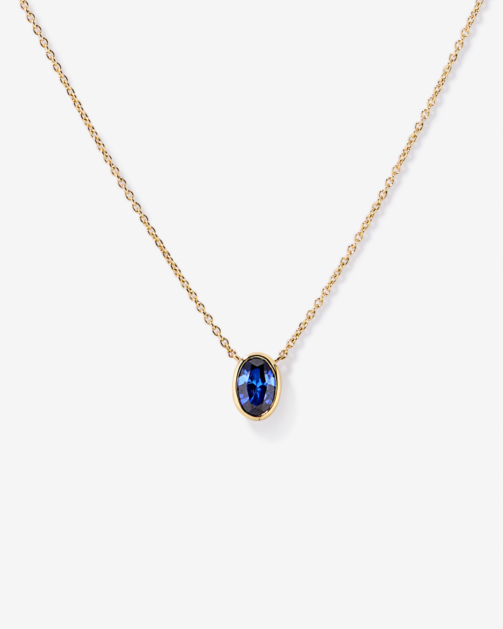 Oval Blue Created Sapphire Bezel Necklace in 10kt Yellow Gold