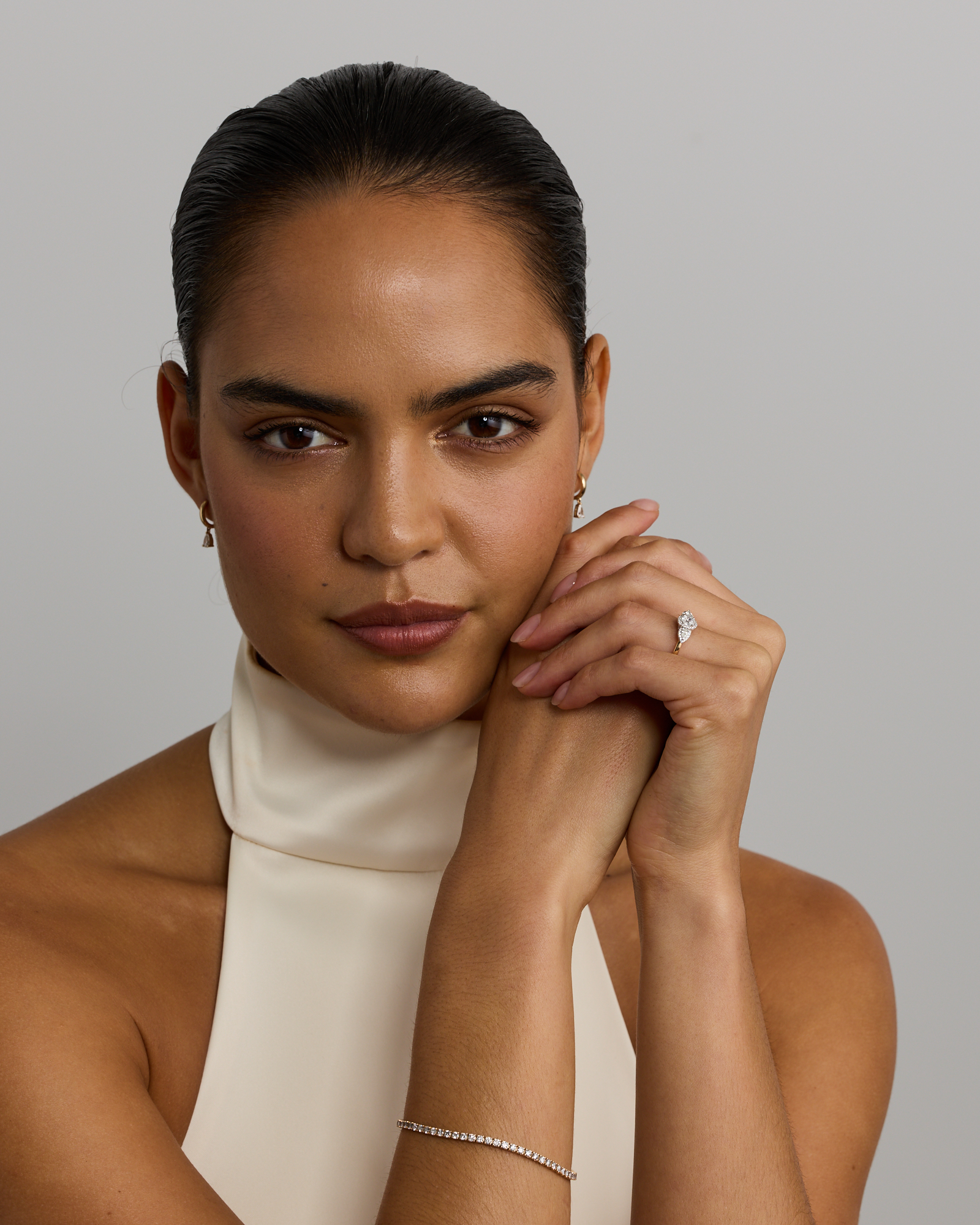 Bague de fiançailles halo en or jaune et blanc 14 carats avec trois diamants ovales forme poire totalisant 0,69 carat.