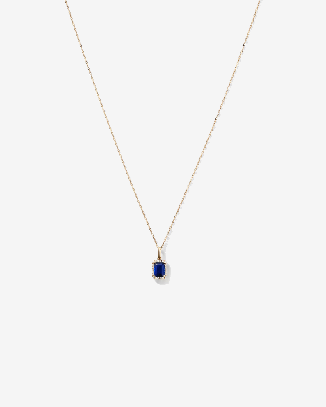 Emerald Cut Created Sapphire and Diamond Halo Pendant with Chain in 10kt Yellow Gold