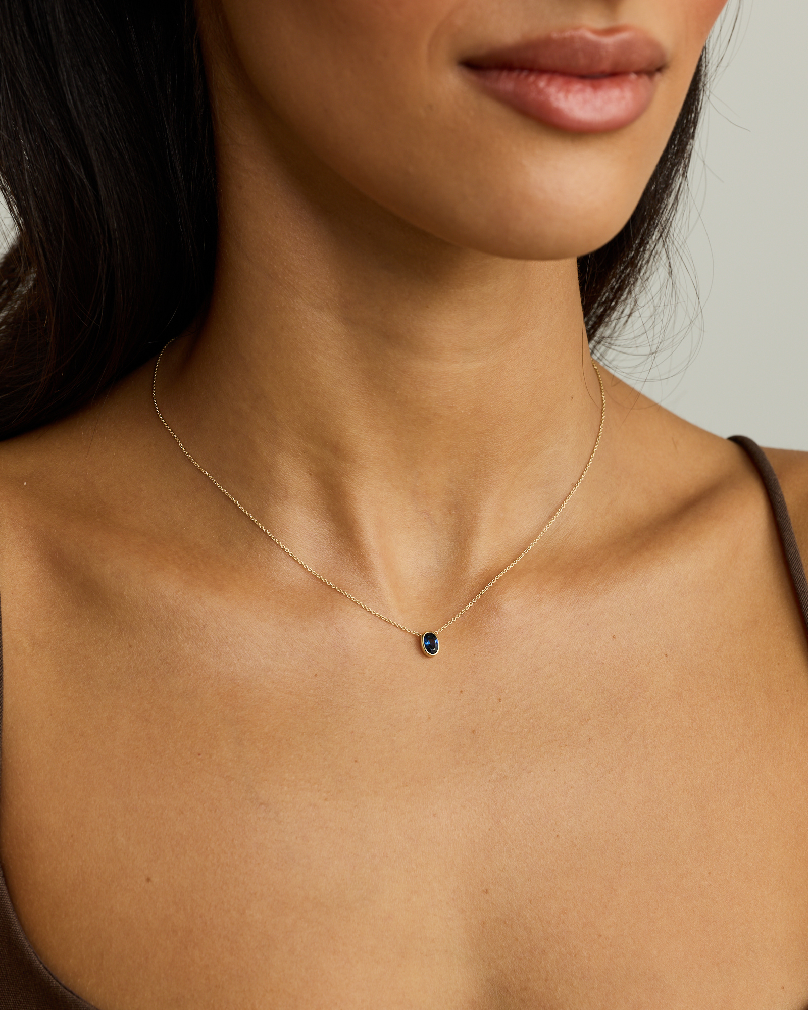 Oval Blue Created Sapphire Bezel Necklace in 10kt Yellow Gold