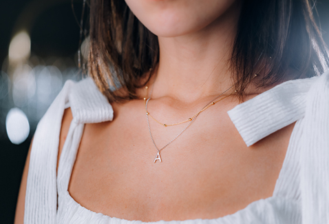 @alishayi wearing dainty necklaces and an initial pendant